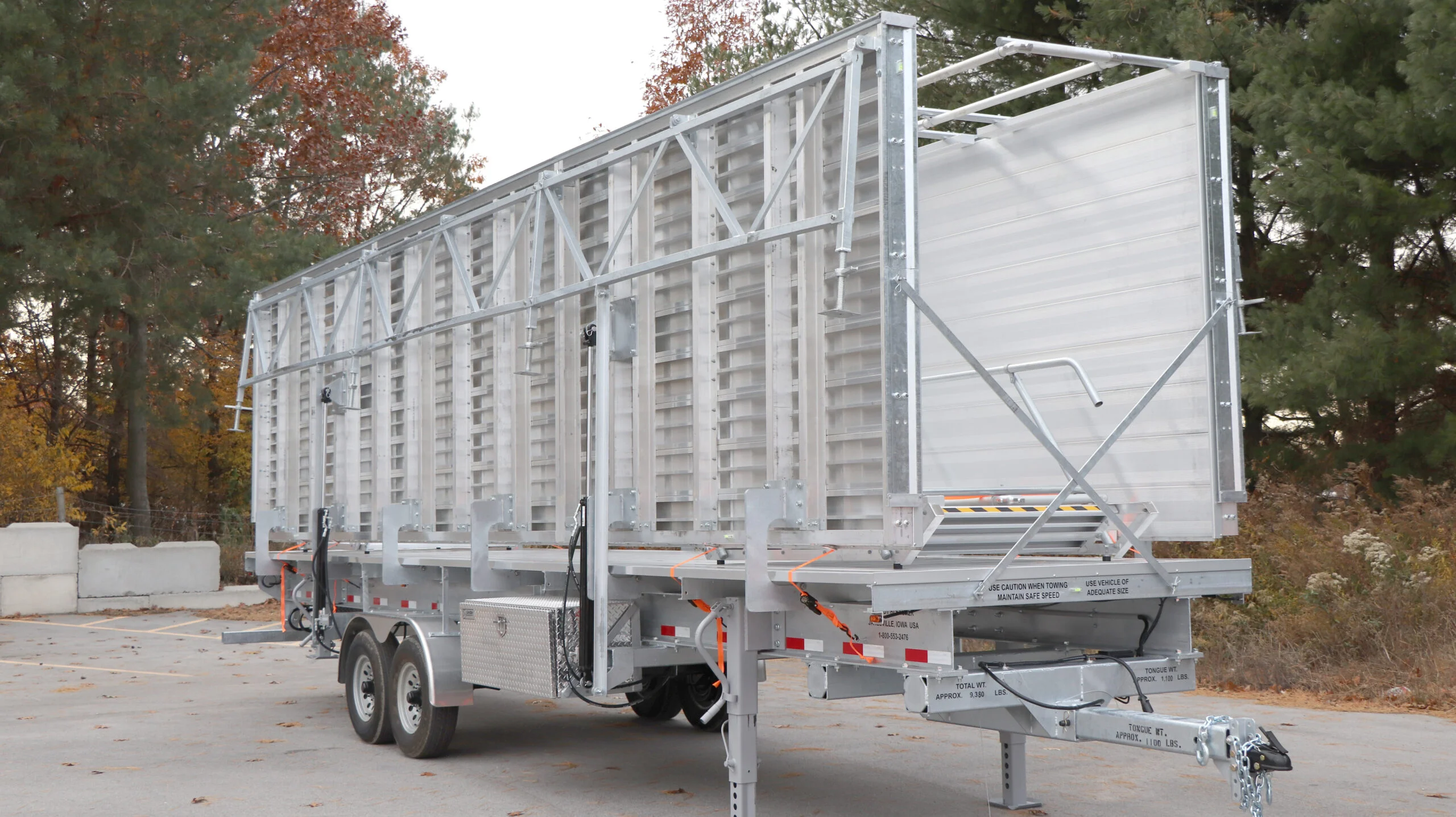 A large metal trailer with a ramp and side rails.