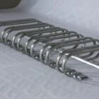 Stainless steel bike rack on a white surface.