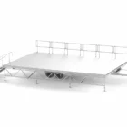 Stage platform with ramp and safety rail.