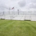 White bleachers on a grassy field.