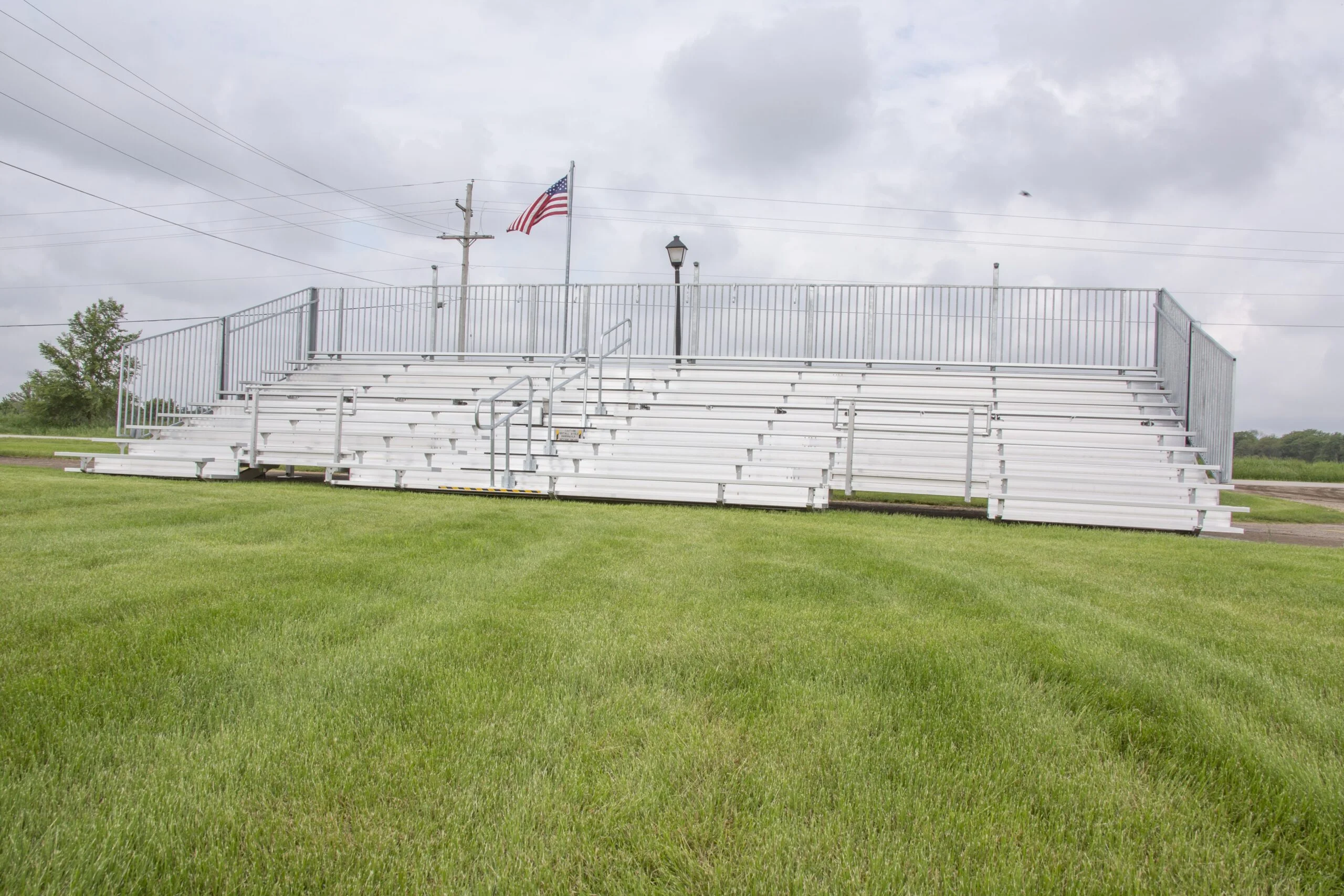 White bleachers on a grassy field.