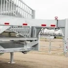 Metal cattle chute with red and white stripes.
