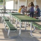 Outdoor picnic tables and benches in a park setting.