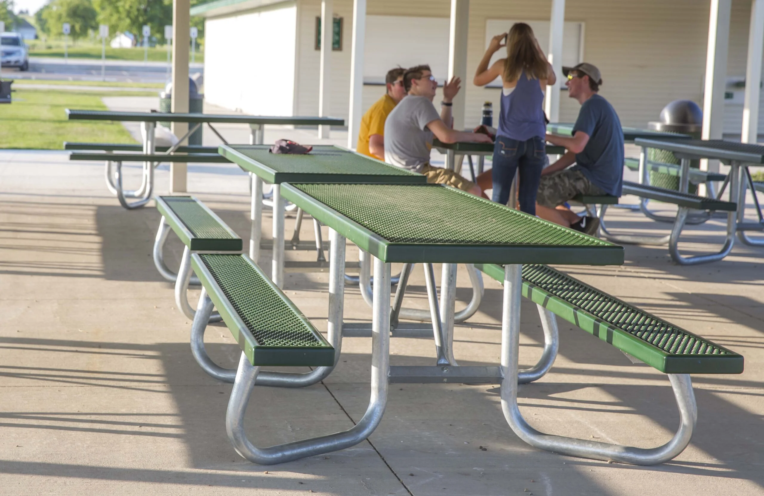 Outdoor picnic tables and benches in a park setting.