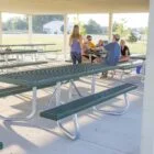 Outdoor picnic tables and benches in a covered area.
