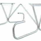 Silver metal bike rack on green background.