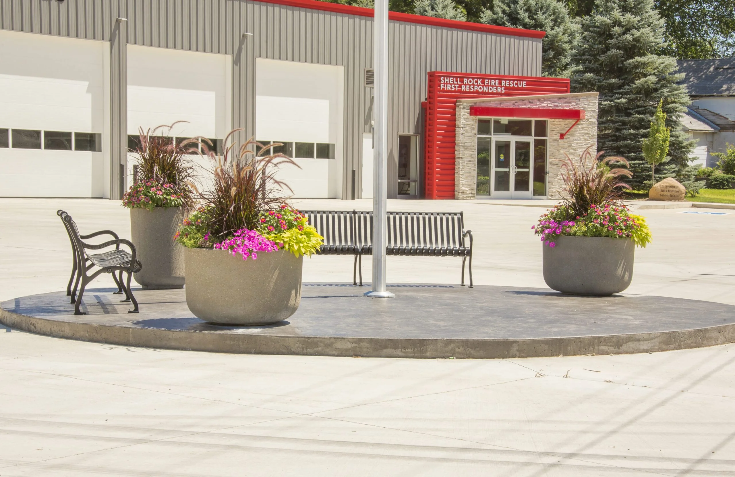 Shell Rock Fire Rescue building entrance with flower pots and benches.