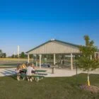 Park picnic area with tables and benches under a covered shelter.