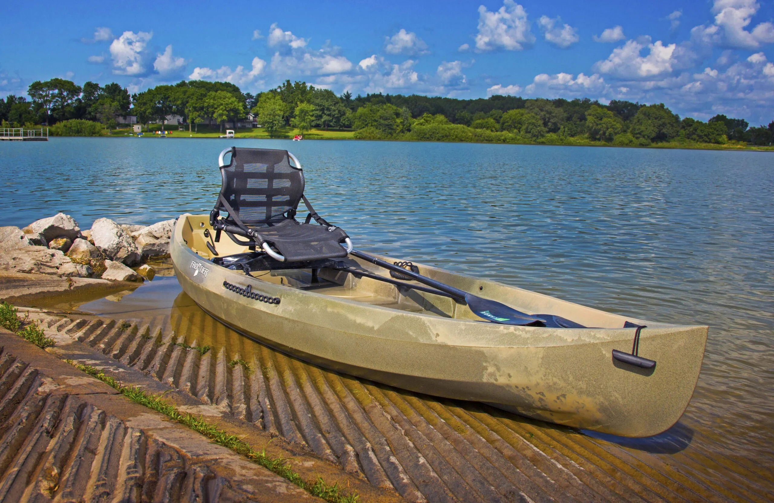 Kayak on dock with paddle and seat.