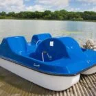 Pedal boat on a dock by a lake.