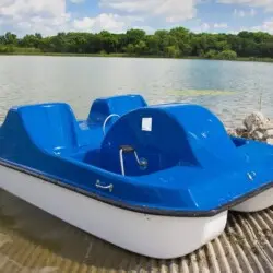 Pedal boat on a dock by a lake.