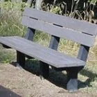 Grey bench in a garden setting.