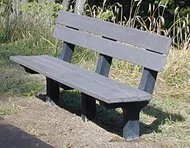 Grey bench in a garden setting.