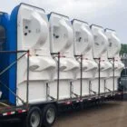 Large white and blue structures on a flatbed trailer.
