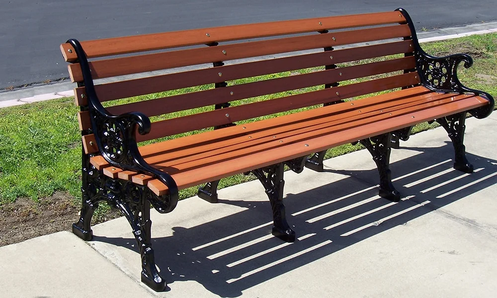 Wooden bench on a sidewalk.