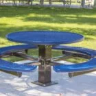 Round blue picnic table in a park setting.
