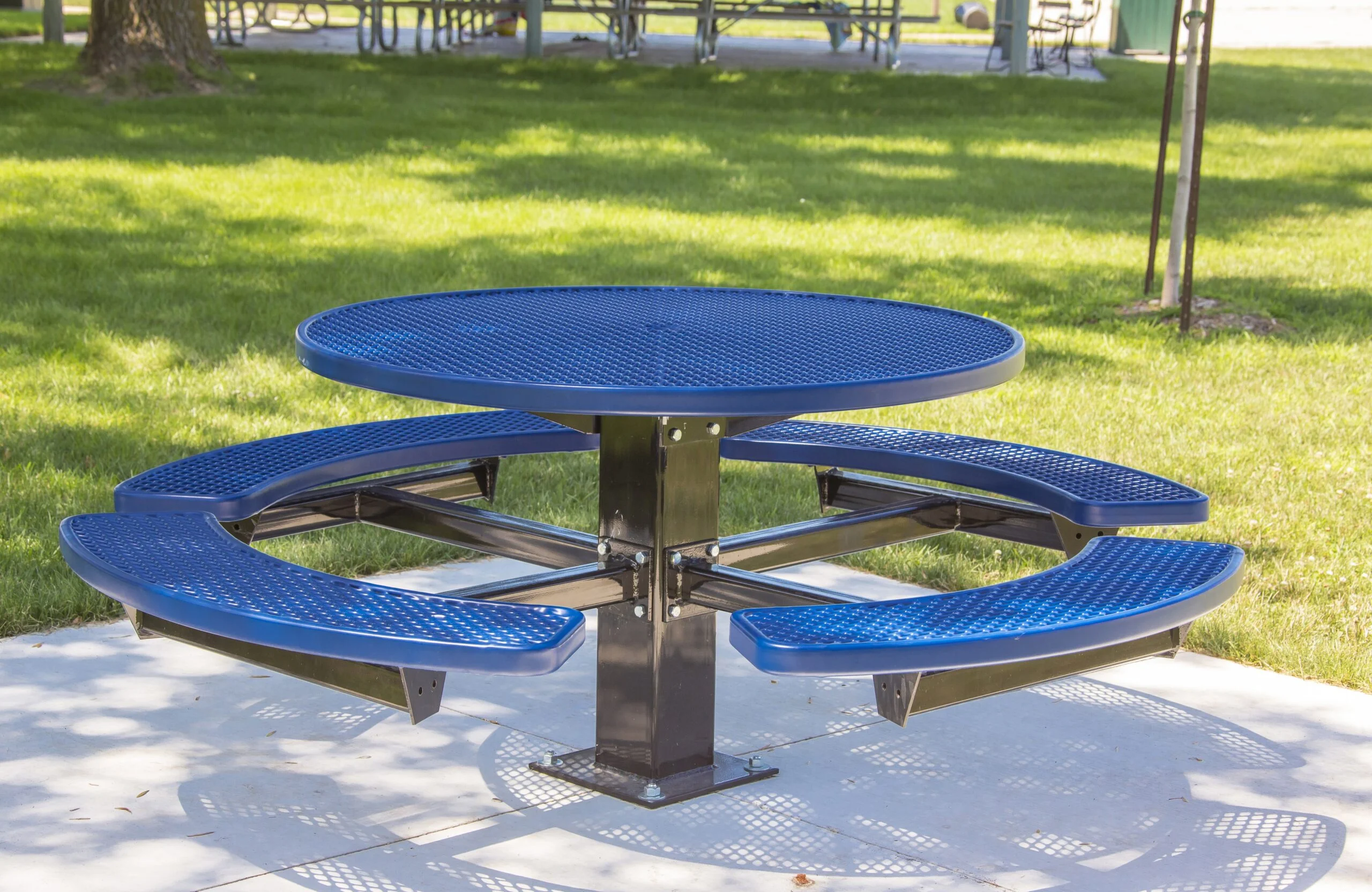 Round blue picnic table in a park setting.