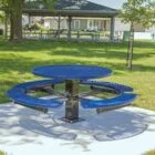 Round blue picnic table in a park setting.