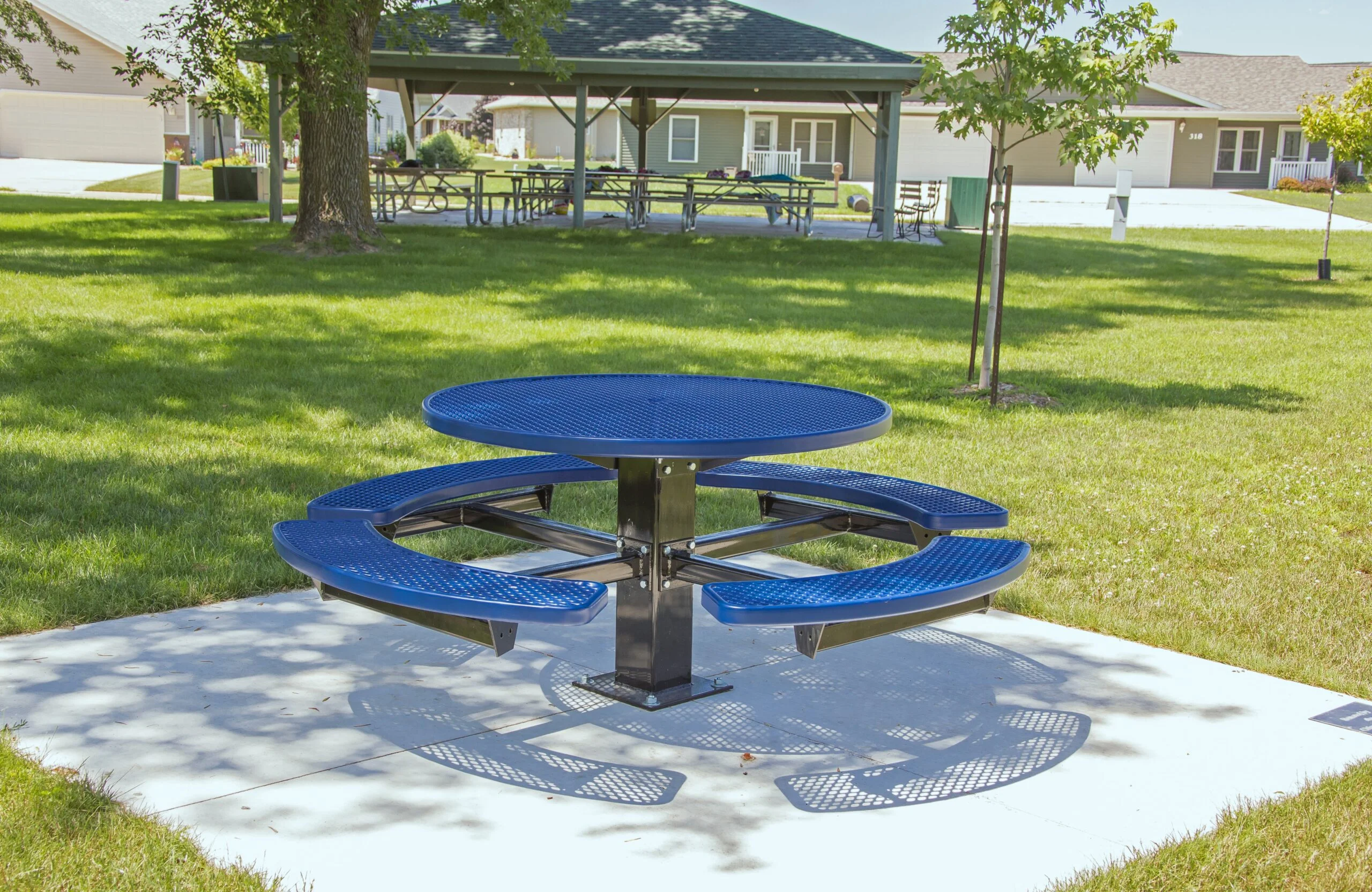 Round blue picnic table in a park setting.