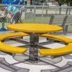 Yellow and black picnic table in a park.