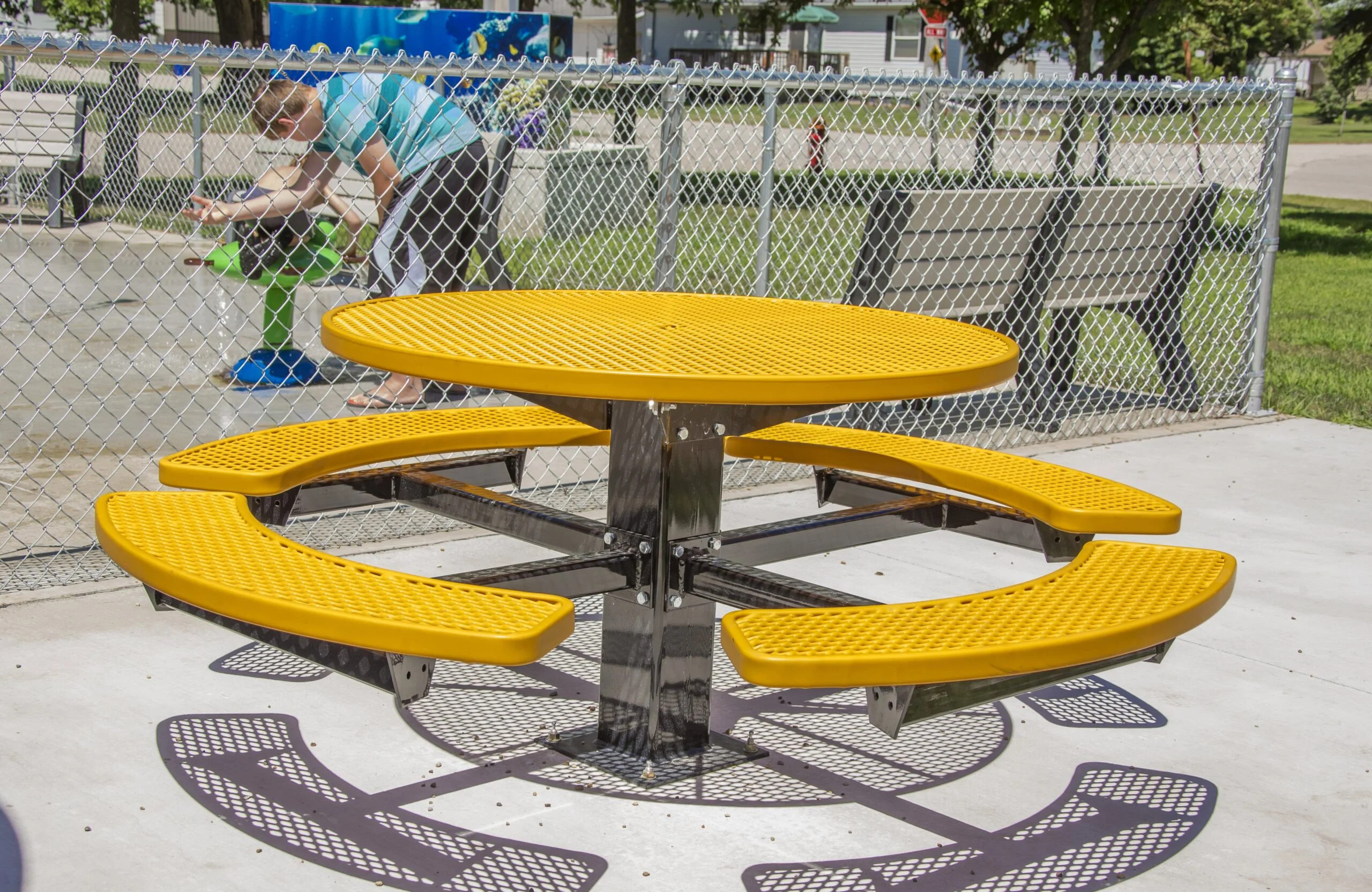 Yellow and black picnic table in a park.