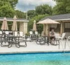 Poolside deck area with lounge chairs and umbrellas.