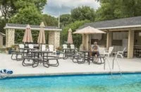 Poolside deck area with lounge chairs and umbrellas.
