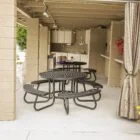 Outdoor patio area with picnic tables and potted plants.