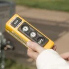Hand holding a yellow device labeled SPX.
