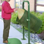 Man using a green outdoor compost bin.