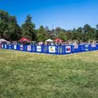 Outdoor event setup with tents and barriers in a park.