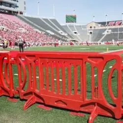 Red plastic barriers on a football field.