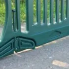 Green plastic barrier on paved surface.