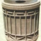 Concrete trash can with a circular opening at the top.
