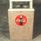 Coca-Cola trash can on concrete surface.