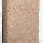 Brick-like object with a rough texture and speckled pattern.