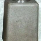 Metallic cylindrical object with a textured surface and circular indentation.