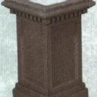 Brown stone pedestal with decorative detailing.