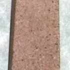 Rectangular object with a rough texture and small dark spots.