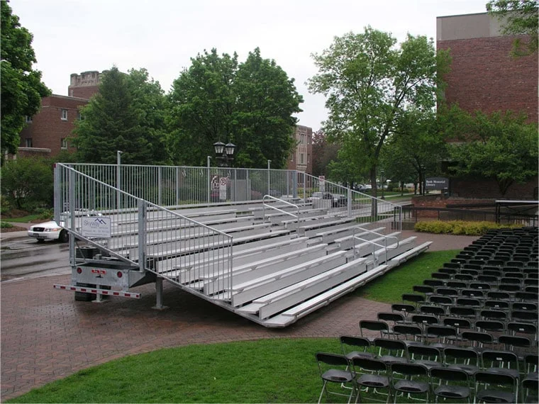Metal bleachers on a trailer in an outdoor setting.