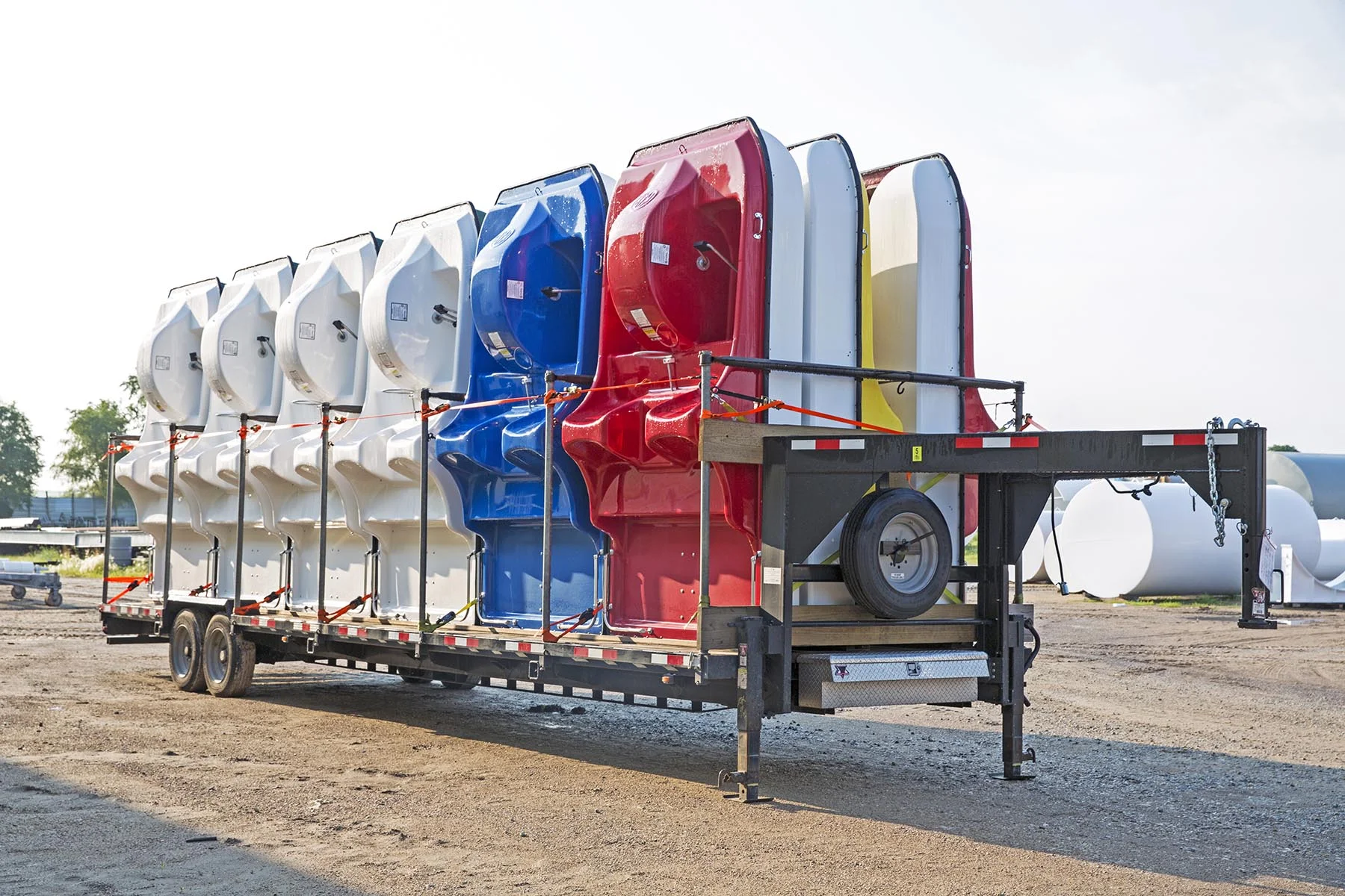 Row of colorful kayaks on a trailer.
