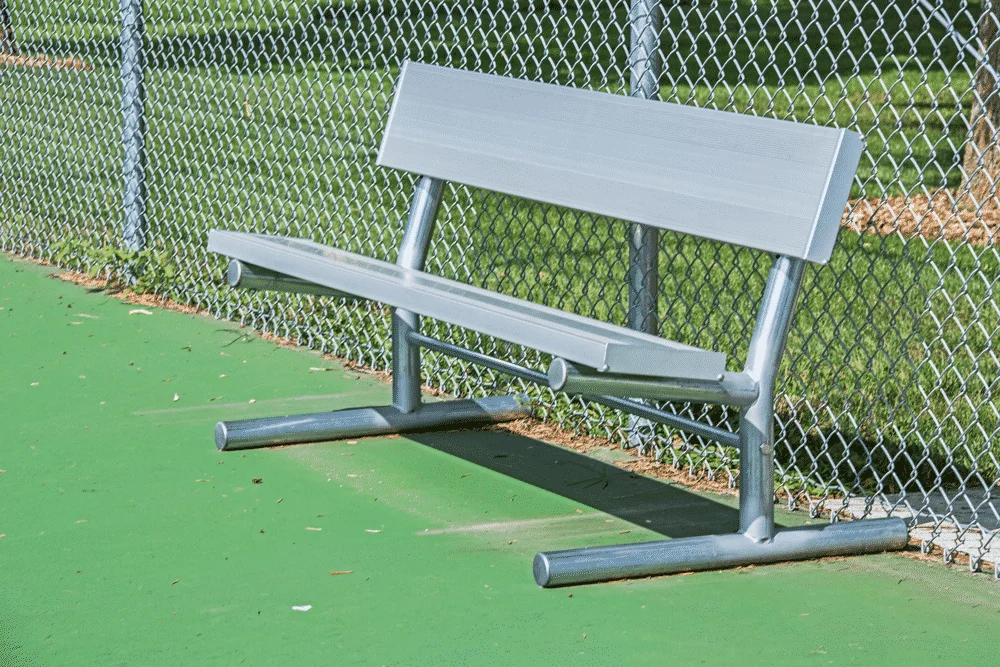 Baseball bench on a green field.