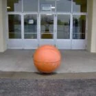 Large orange ball in front of a building.