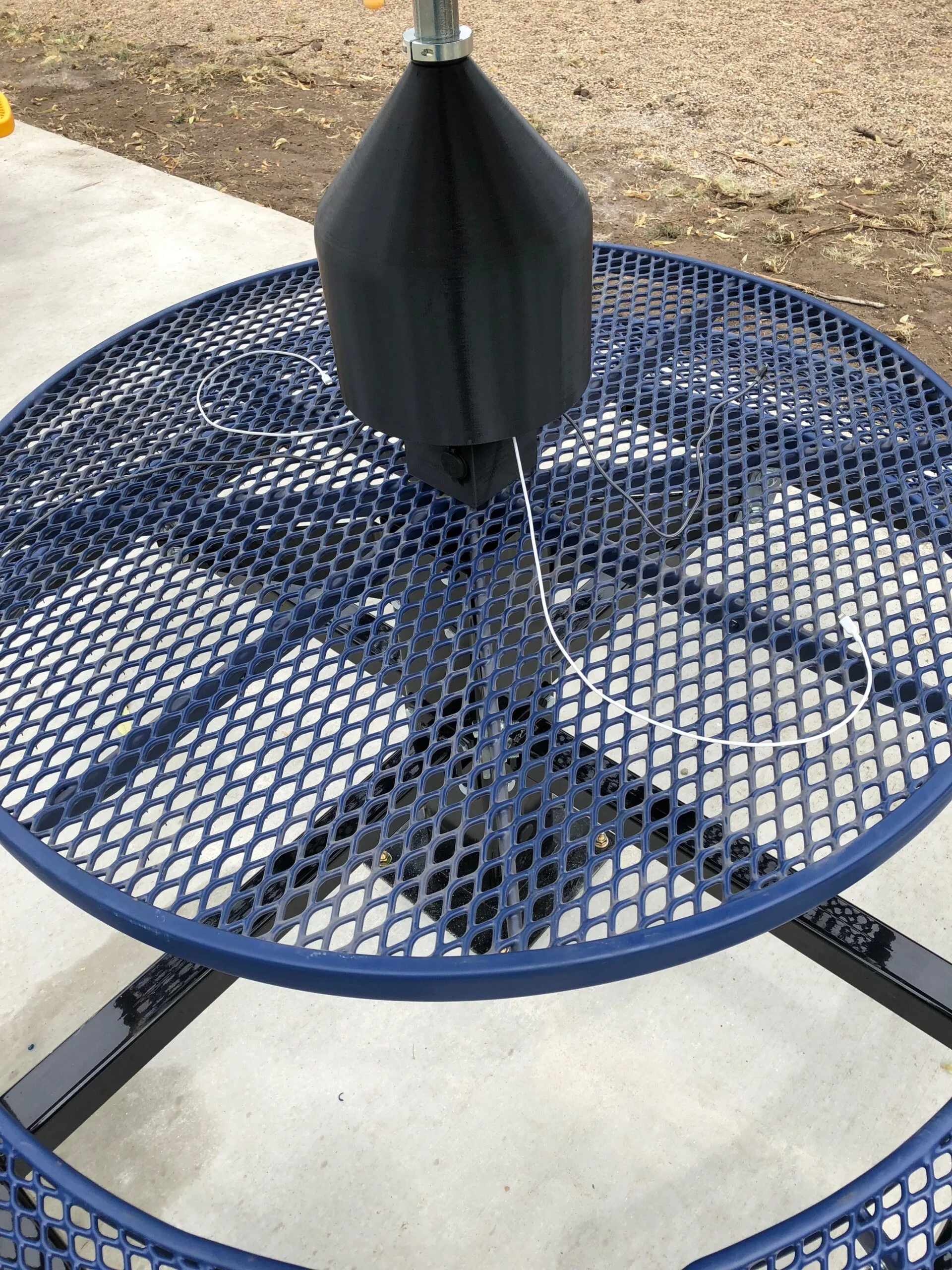 Blue mesh table with umbrella base.