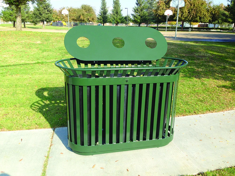 Green trash can in a park.