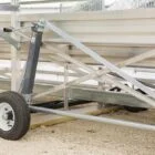 Metal trailer ramp on gravel surface.