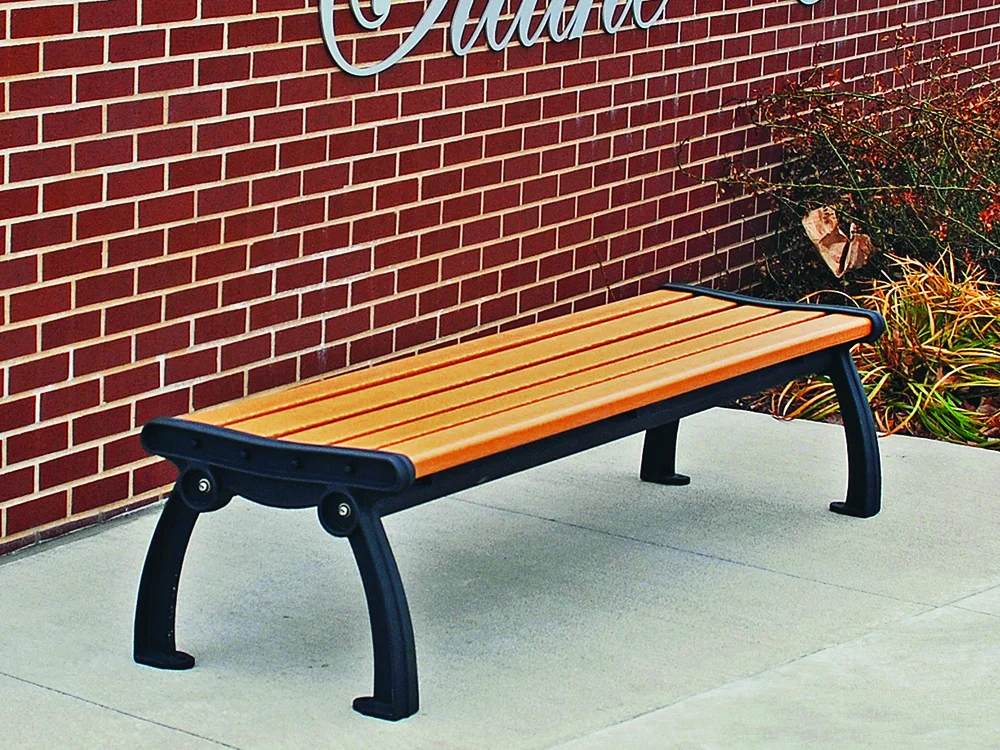 Outdoor bench against brick wall.