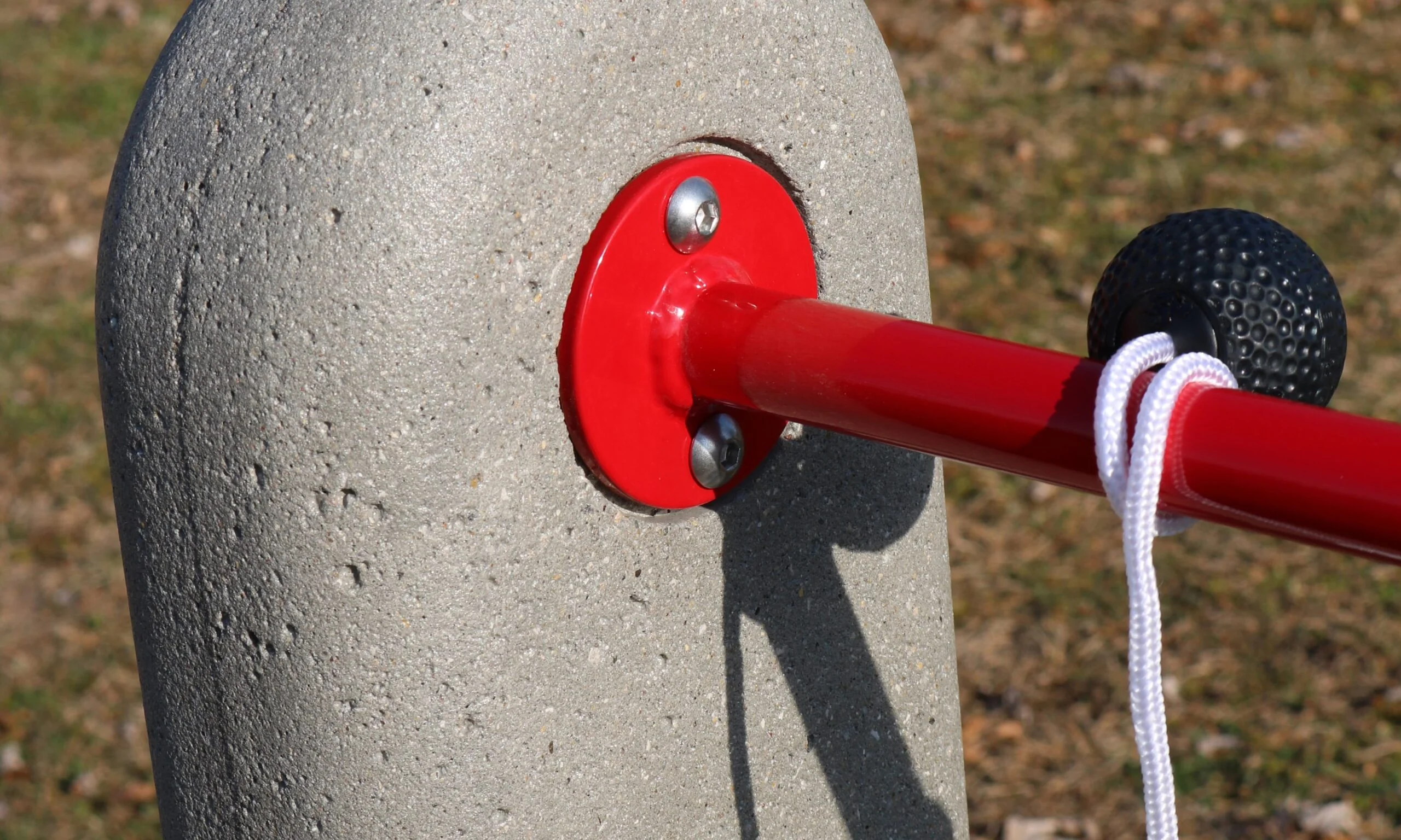 Red metal pole attached to a concrete post.