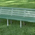 Green park bench on grass.