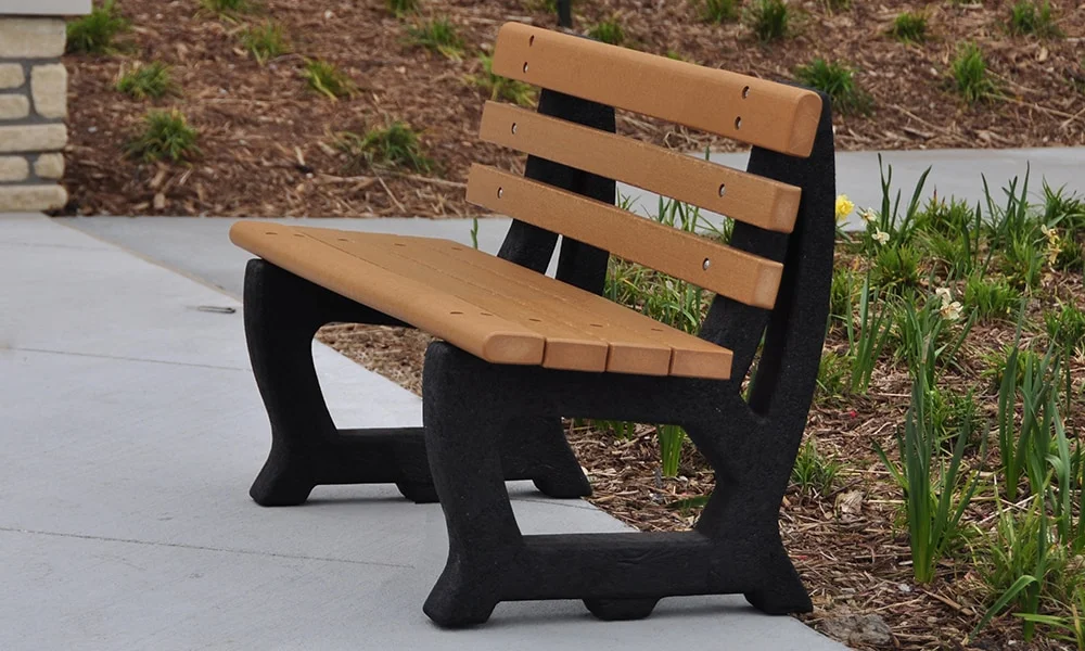 Modern outdoor bench with wooden slats and black legs.